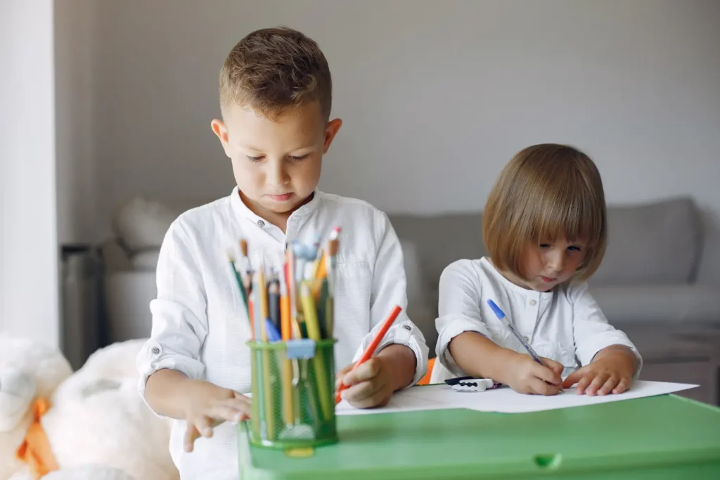 Niños haciendo deberes y dibujos con lápices de colores